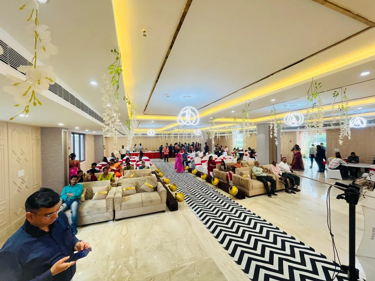 Guests and sofa seating in Pearl banquet hall beside a chevron aisle