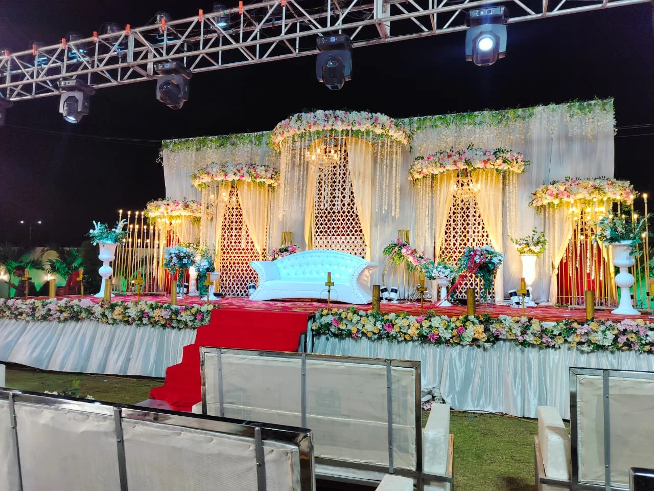 Outdoor wedding stage with floral decorations and red steps